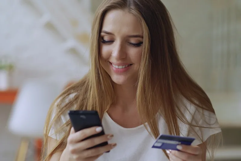 família brasileira revisando milhas e pontos sobre “Exemplo numérico com R$ 430,00 por mês” com cartão de crédito e smartphone em apartament