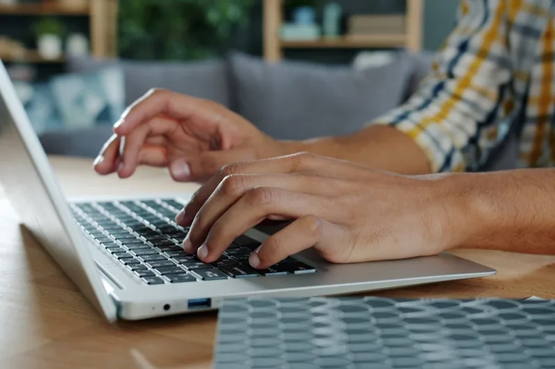 microempreendedora brasileira anotando aportes mensais sobre “Como mapear sua situação atual em reais” com tablet com notícias econômicas em