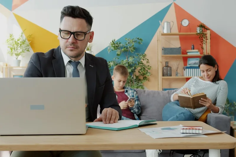 jovem adulto brasileiro embalando produtos para envio sobre “Comparativo entre os tipos de renda extra na declaração” com fones e notebook e