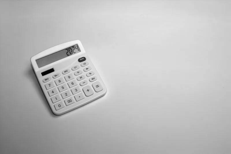 trabalhador brasileiro em home office calculando CET na planilha sobre “Estratégia prática: de CET a capacidade de parcela” com calculadora