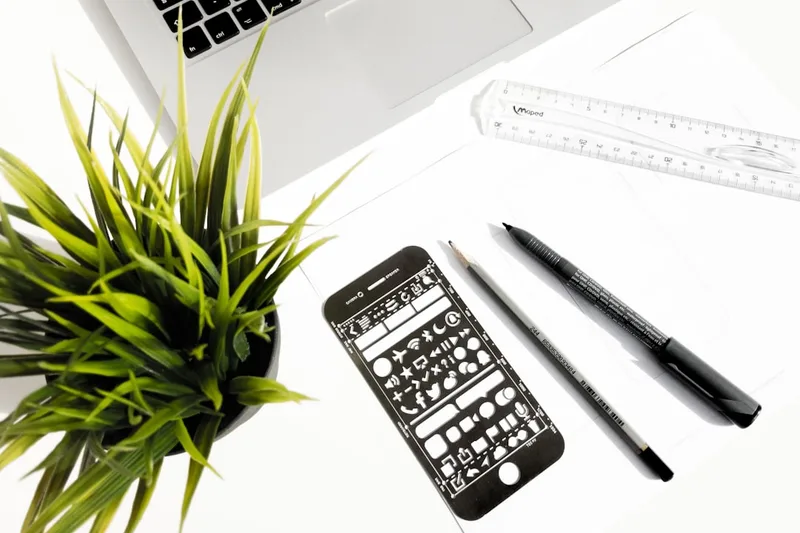 estudante universitário brasileiro anotando gastos em planilha sobre “Erros caros que brasileiros cometem com erros financeiros” com smartph