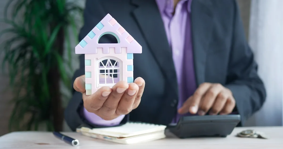 vendedor brasileiro ilustrando financiamento imobiliário em escrivaninha perto da janela (Financiamento Imobiliário: Entrada, CET e Cuidados