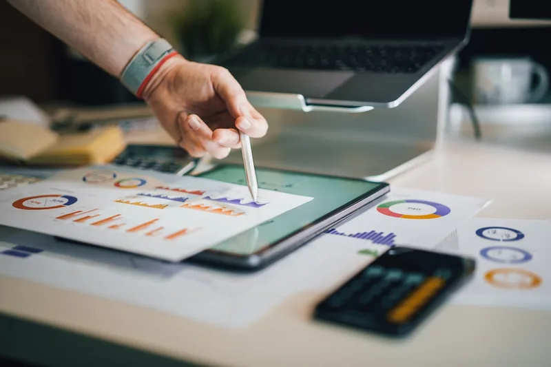 pessoa brasileira adulta pesquisando investimentos no notebook sobre “Estratégia prática: de perfil de risco a diversificação” com tablet co