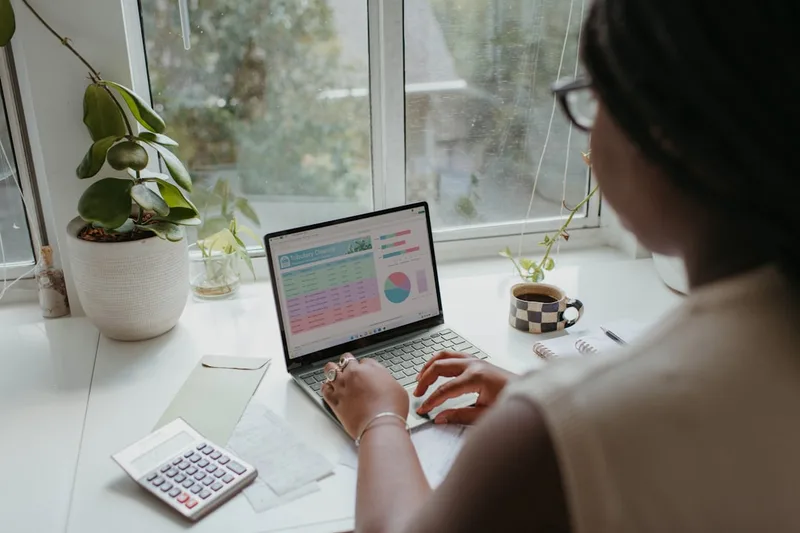 casal brasileiro pesquisando investimentos no notebook sobre “Erros caros que brasileiros cometem com investir pouco di…” com calculadora e