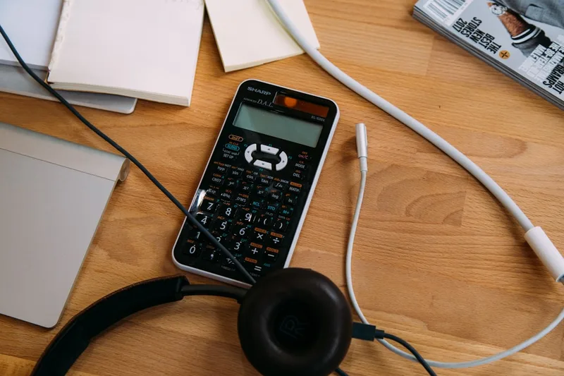 vendedor brasileiro preenchendo declaração no computador sobre “Por que IR investimentos muda o fim do mês no Brasil” com calculadora e cane