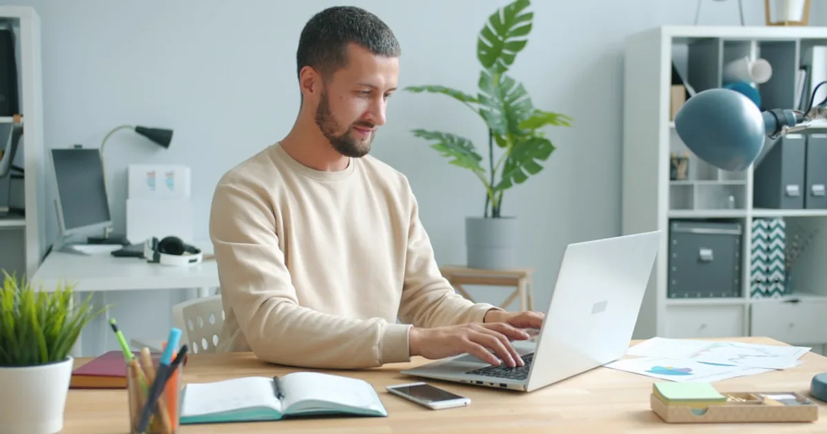 trabalhador brasileiro em home office ilustrando juros compostos em sofá da sala com tablet (Juros Compostos Explicados de Forma Simples (co