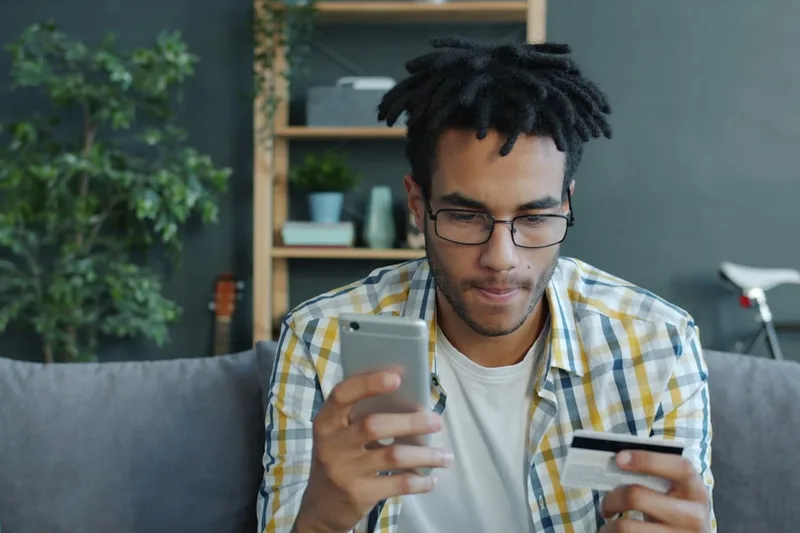 homem brasileiro de meia-idade ensinando criança a poupar sobre “Por que juros compostos muda o fim do mês no Brasil” com tablet educativo e
