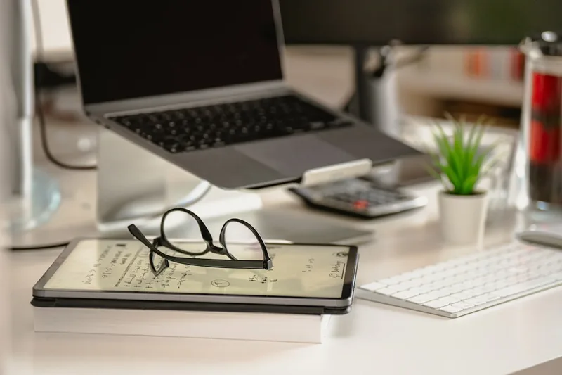trabalhador brasileiro em home office checando app de notícias sobre “Por que reajuste INSS muda o fim do mês no Brasil” com agenda com data