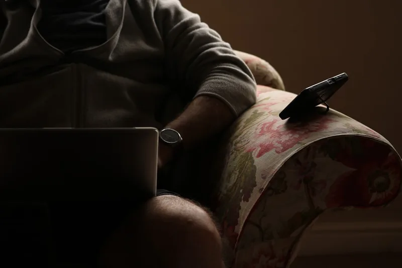 Contexto Brasil: pessoa em videochamada de trabalho paralelo com fones (Como funciona o Imposto de Renda com duas fontes de renda)